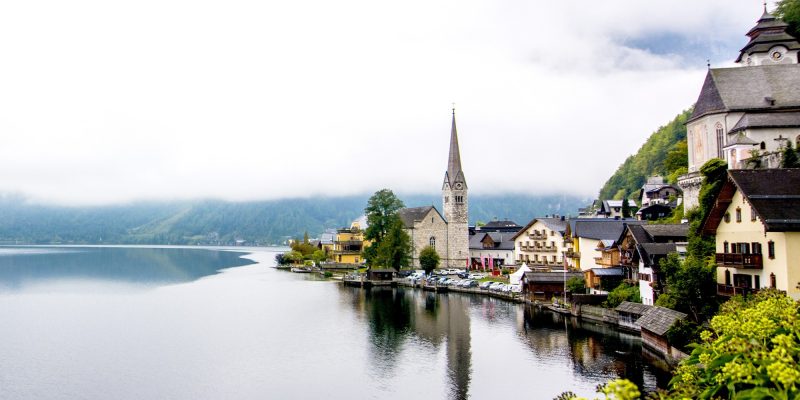 A calm blue lake mirroring the sky, mountain ranges setting a picture-perfect background, and pastel lakeside houses lending the historic town a storybook vibe – I did my best but words fail to do this town justice. If you’re in for a visual tour or ready to start planning your trip, this Hallstatt travel guide will surely leave you in love with this town.